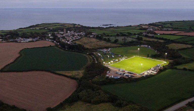 Aerial view of Mousehole AFC pitch illuminated by floodlights